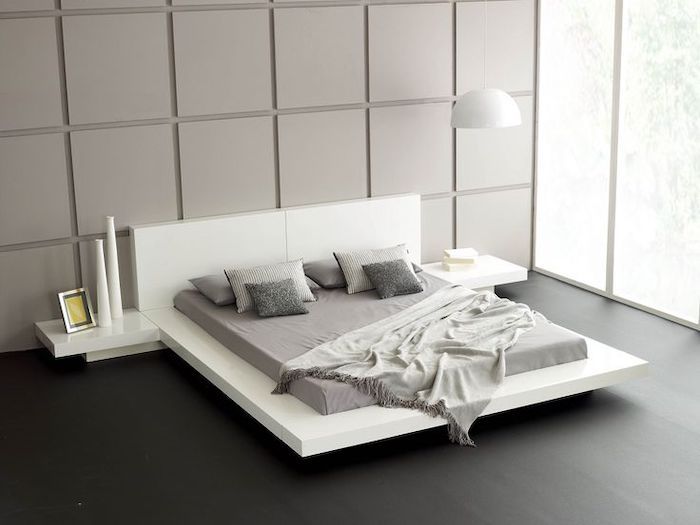 black wooden floor, white bed frame and shelves, grey tiled wall .