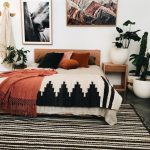 Bohemian style bedroom with orange accents and striped black and .