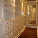 long, narrow walk-in closet design with creamy white built-in .