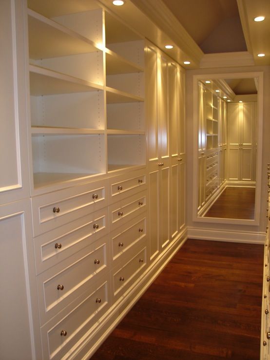 long, narrow walk-in closet design with creamy white built-in .